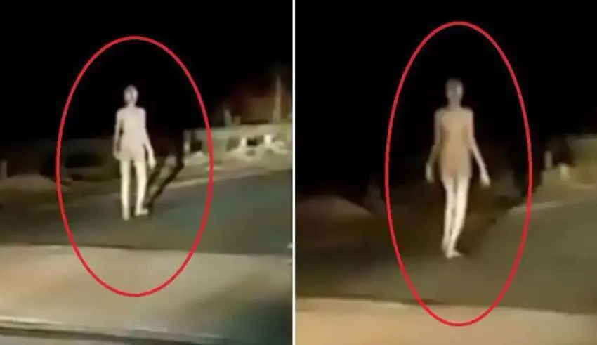 Várias pessoas veem um humanoide com membros longos caminhando em uma ponte na Índia